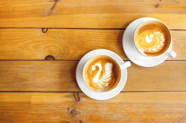 Imagen de dos tazas de capuchino con un patrón