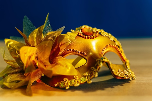Imagen de una elegante máscara veneciana dorada sobre fondo de madera