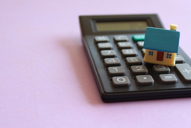 Foto imagen de enfoque selectivo de la casa de juguetes y la calculadora concepto de cálculo de costos de propiedad