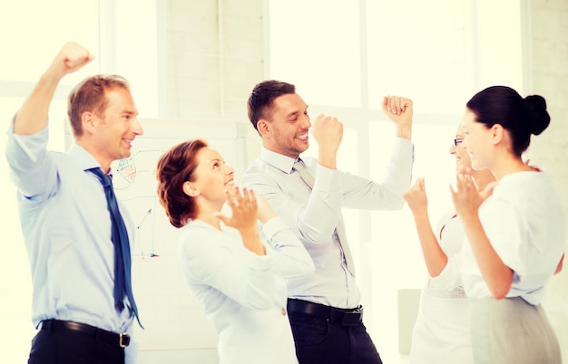 imagen de un equipo de negocios feliz celebrando la victoria en el cargo