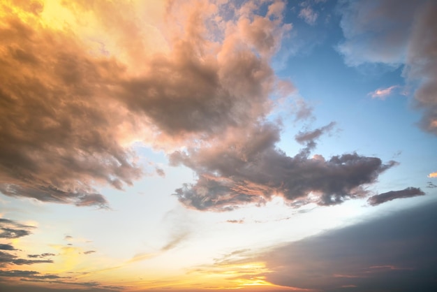 Imagen espectacular del paisaje de la puesta de sol con nubes hinchadas iluminadas por el sol naranja y el cielo azul