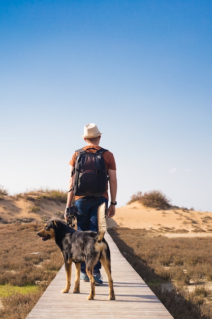 Imagen de estilo de vida al aire libre de hombre que viaja con lindo perro. Concepto de turismo.