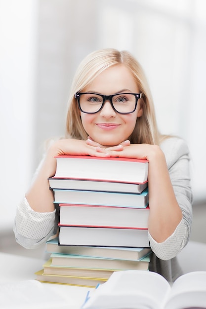 imagen de estudiante sonriente con pila de libros