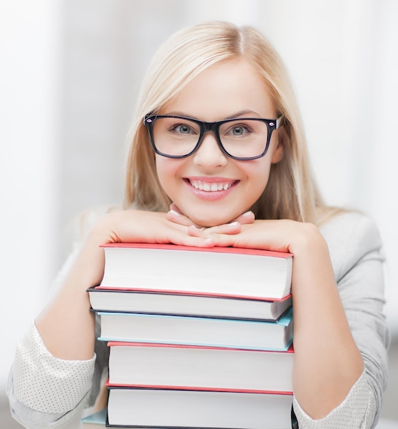 imagen de estudiante sonriente con pila de libros