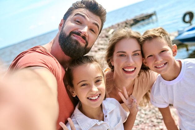 Una imagen de la familia sonriente feliz divirtiéndose en la playa