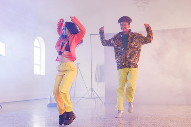 Imagen de felices y diversos bailarines de hip hop masculinos y femeninos en el estudio. Concepto de danza, ritmo, movimiento y entrenamiento.