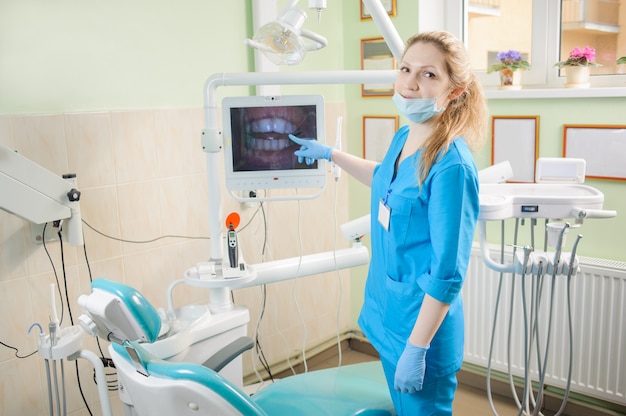 Imagen femenina de la demostración del dentista de dientes en el ordenador