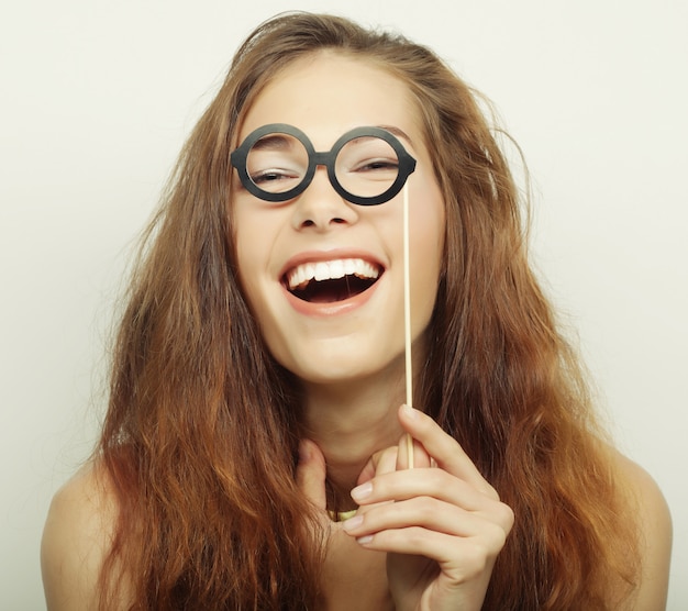 Imagen de fiesta. Juguetonas jóvenes sosteniendo una fiesta gafas.