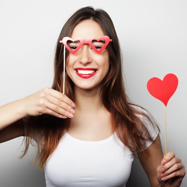 Imagen de fiesta Mujer joven juguetona sosteniendo un corazón de fiesta