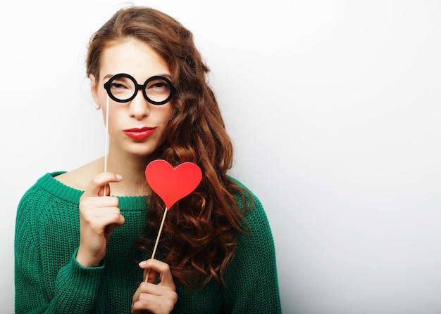 Imagen de fiesta Mujer joven juguetona sosteniendo unas gafas de fiesta