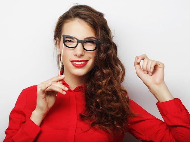 Foto imagen de fiesta mujer joven juguetona sosteniendo unas gafas de fiesta