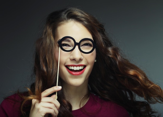 Imagen de fiesta Mujeres jóvenes juguetonas sosteniendo unas gafas de fiesta