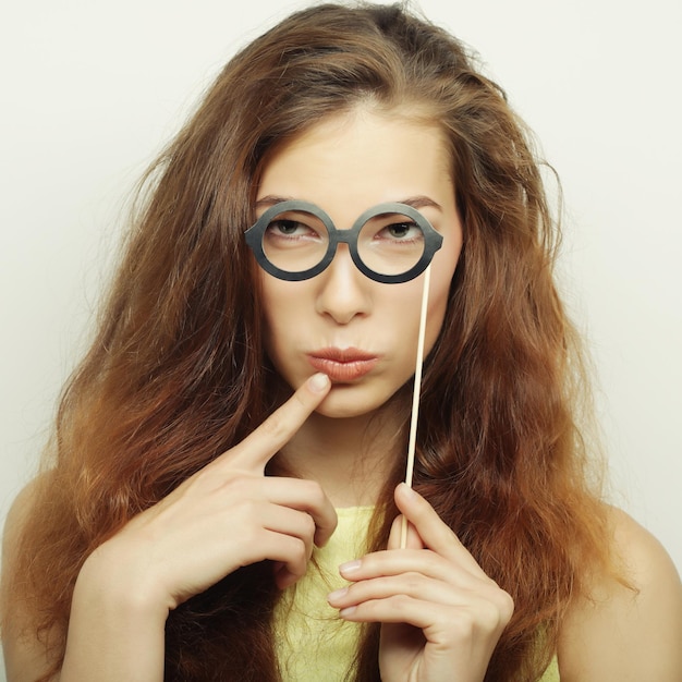 Imagen de fiesta Mujeres jóvenes juguetonas sosteniendo unas gafas de fiesta