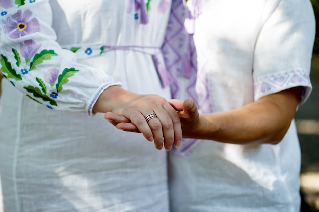 Imagen filtrada, pareja cogidos de la mano en el tema al aire libre de la boda