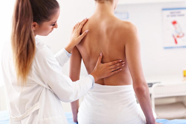Imagen de fisioterapeuta ayudando a un paciente con problemas de espalda en la clínica