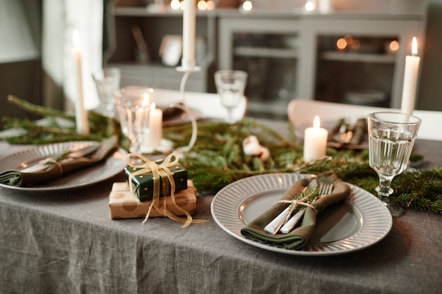 Imagen de fondo de acogedor comedor decorado para navidad con velas encendidas y ramas frescas de abeto ...