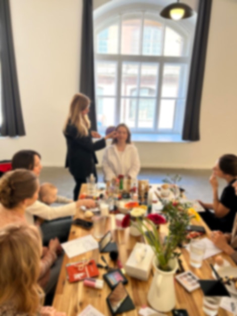 Una imagen de fondo borrosa siluetas de individuos una reunión de mujeres aprendiendo técnicas de maquillaje durante una clase maestra