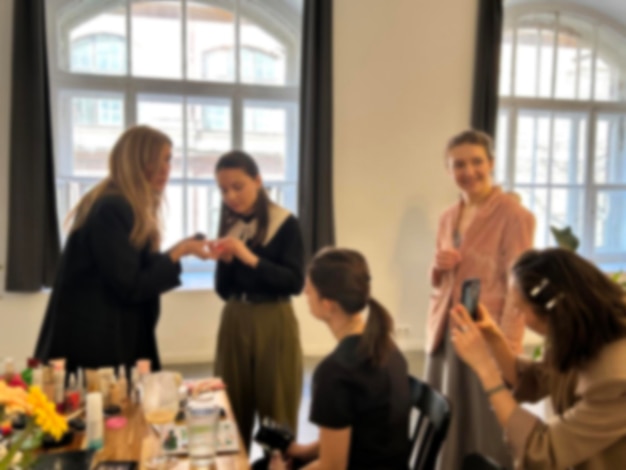 Una imagen de fondo borrosa siluetas de individuos una reunión de mujeres aprendiendo técnicas de maquillaje durante una clase maestra