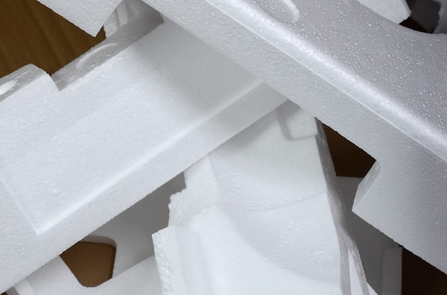 Imagen de fondo con cartulina de color beige y cajas de espuma de poliestireno desechadas como basura.