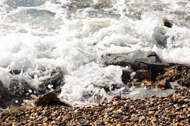 Imagen de fondo hermosa de guijarros en la playa con olas y mar.