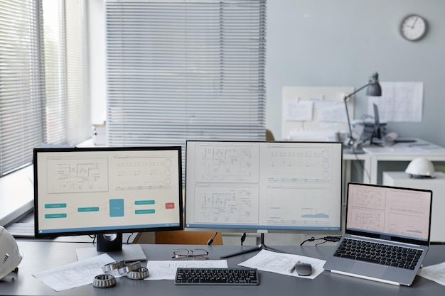 Imagen de fondo del lugar de trabajo de los ingenieros en la oficina con planos y planos en múltiples pantallas de computadora espacio de copia