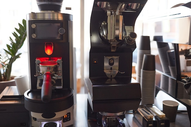 Imagen de fondo de máquinas de café y vasos de papel en la cafetería o cafetería, espacio de copia