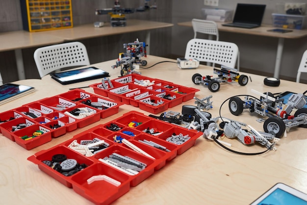 Imagen de fondo de piezas de construcción de robots en contenedores sobre la mesa en robótica y clase de ingeniería en la escuela moderna, espacio de copia