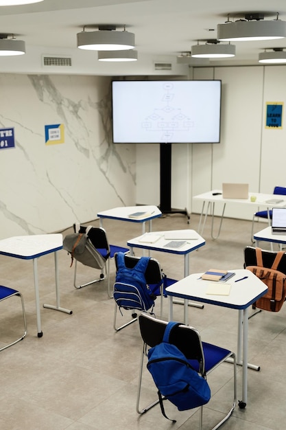 Foto imagen de fondo vertical del aula de programación en la escuela moderna con código en pantalla, espacio de copia