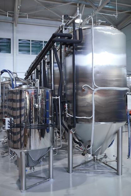 Imagen de fondo vertical de tanques de filtración y fermentación en la moderna cervecería industrial, espacio de copia
