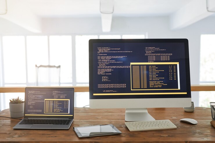 Foto imagen de fondo de la vista frontal de dos computadoras con código de programación en la pantalla en el interior mínimo de la oficina en casa con detalles en madera, espacio de copia