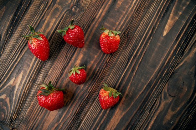 Imagen de fresas rojas frescas sobre tabla de madera