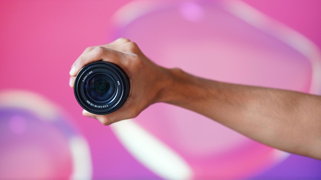 Imagen frontal de una lente de cámara con fondo rosa