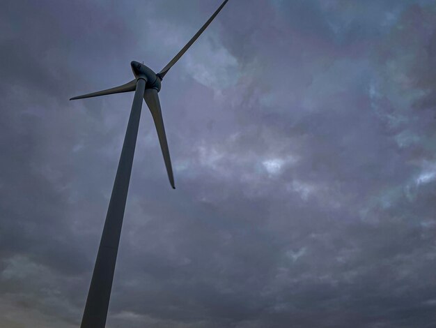 Una imagen de un generador de turbina eólica bajo un cielo nublado