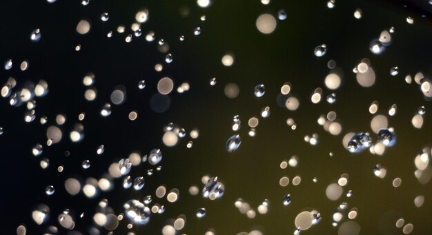 Foto imagen de gotas de lluvia de agua levitando en el aire contra el sol bokeh