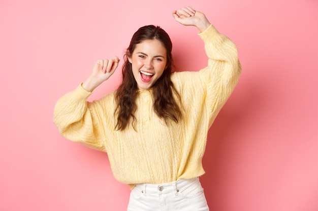 Foto imagen de una hermosa mujer caucásica divirtiéndose bailando y disfrutando de la fiesta levantando las manos en un ambiente relajado...