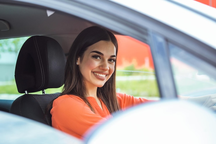Foto imagen de una hermosa mujer joven conduciendo un coche y sonriendo retrato de una mujer feliz dirigiendo un coche con el cinturón de seguridad puesto