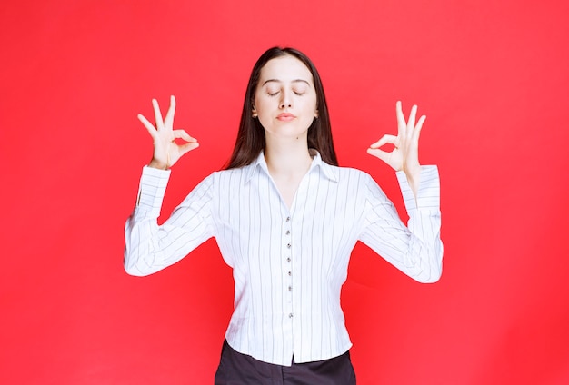 Imagen de hermosa mujer joven de pie y haciendo meditación.