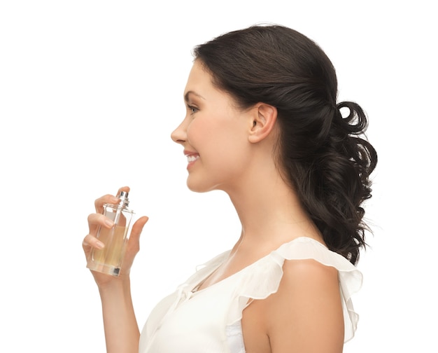 Imagen de hermosa mujer rociando perfume en su cuello
