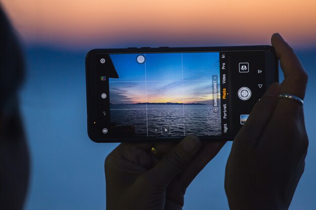 La imagen de la hermosa puesta de sol en el mar en el teléfono