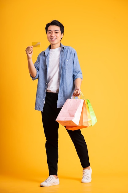 Imagen de hombre asiático posando sobre un fondo amarillo