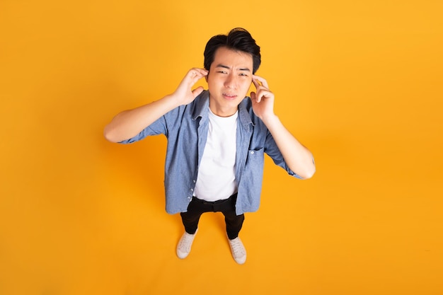 Imagen de hombre asiático posando sobre un fondo amarillo