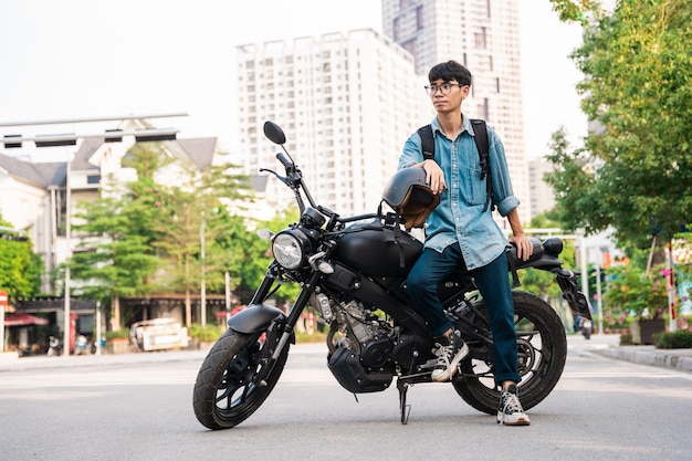Imagen de un hombre asiático sentado en su motocicleta