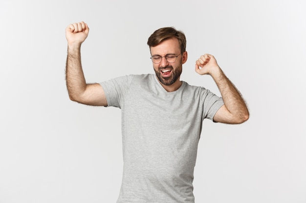 Imagen de hombre emocionado en camiseta gris y gafas