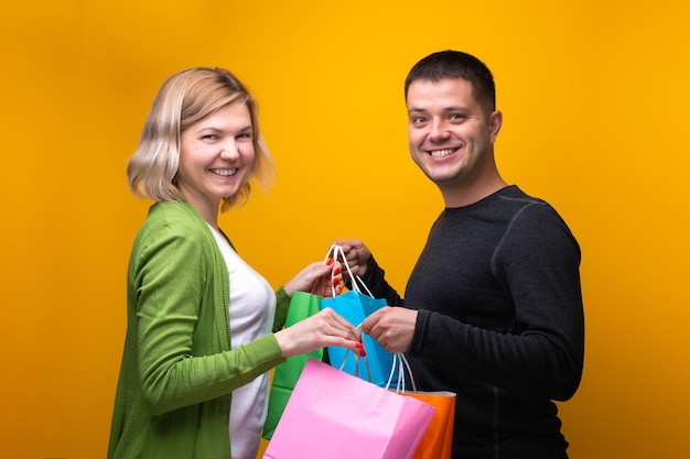 Imagen de hombre feliz y mujer rubia con bolsas de compras