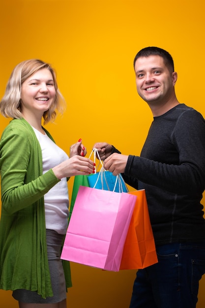 Imagen de hombre feliz y mujer rubia con bolsas de compras