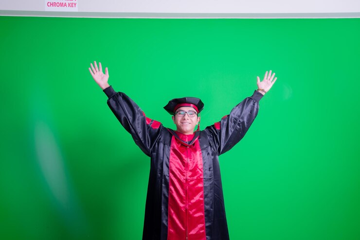 una imagen de un hombre con una gorra de graduación y un fondo verde