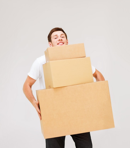 Foto imagen de hombre joven cargando cajas de cartón