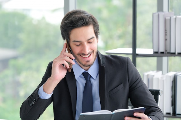 La imagen de un hombre de negocios en un escritorio usando un teléfono