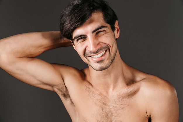 Imagen de un hombre sonriente joven desnudo hermoso que presenta aislado.