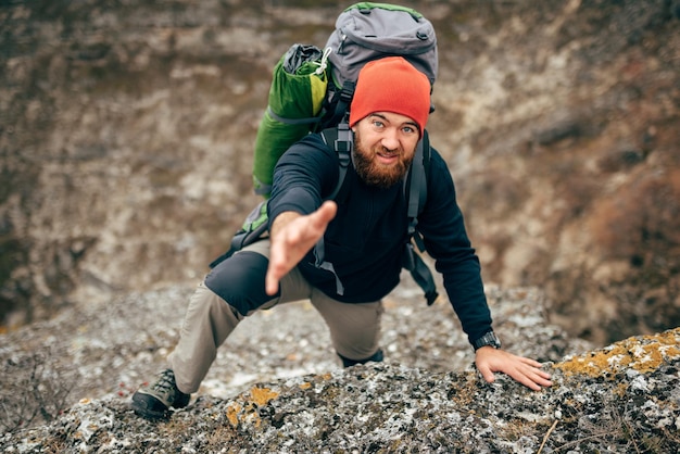 Imagen horizontal del hombre barbudo viajero haciendo senderismo y montañismo durante su viaje.